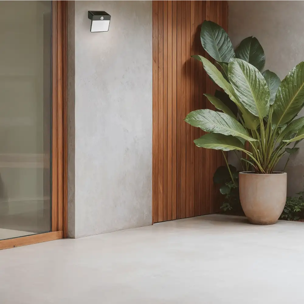 Aplique solar Yarixa LED 2.2W 2700K Philips negro IP44 con sensor instalado en pared exterior