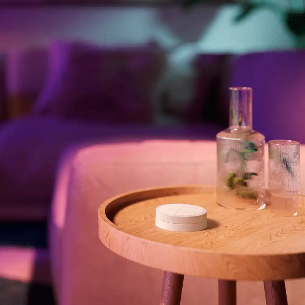 Interruptor Tap Switch blanco Philips Hue sobre mesa en ambiente iluminado.