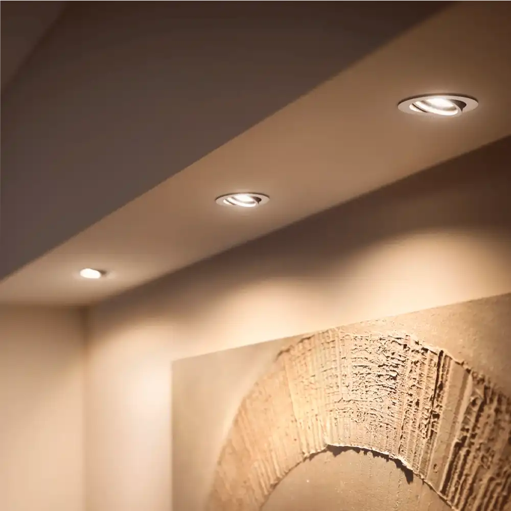 Pack 3 empotrados Milliskin R Philips Hue LED 4.2W blanco White Ambience instalados en techo con luz cálida.