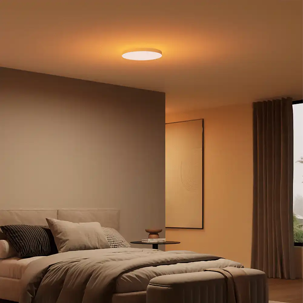 Plafón de techo Datura P Philips Hue blanco instalado en dormitorio con iluminación cálida ambiental