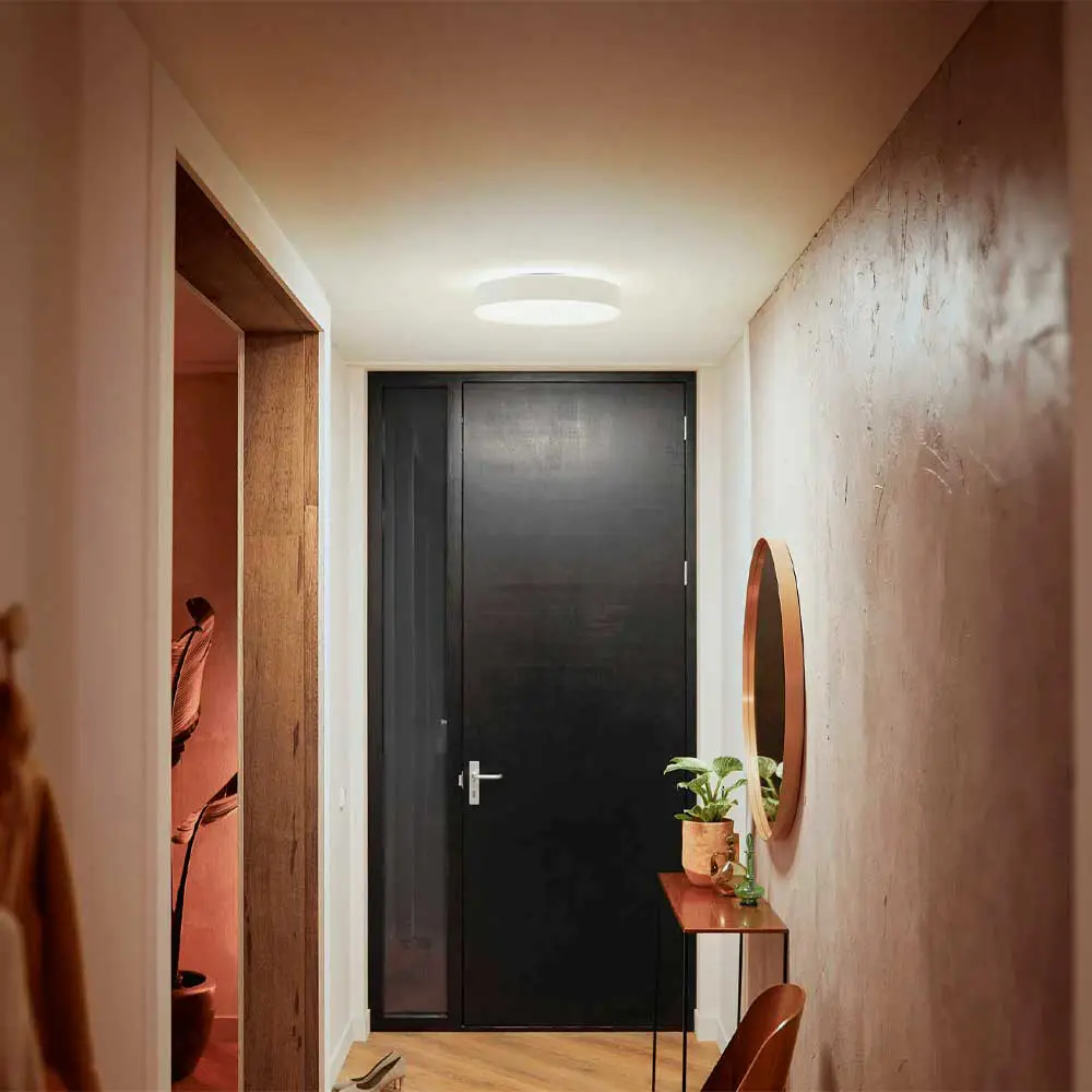 Plafón de techo Enrave M Philips Hue blanco iluminando pasillo moderno con luz blanca cálida