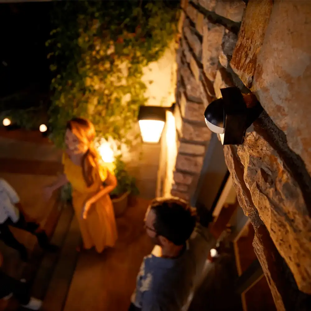 Sensor de movimiento exterior Philips Hue instalado en fachada iluminando entrada.