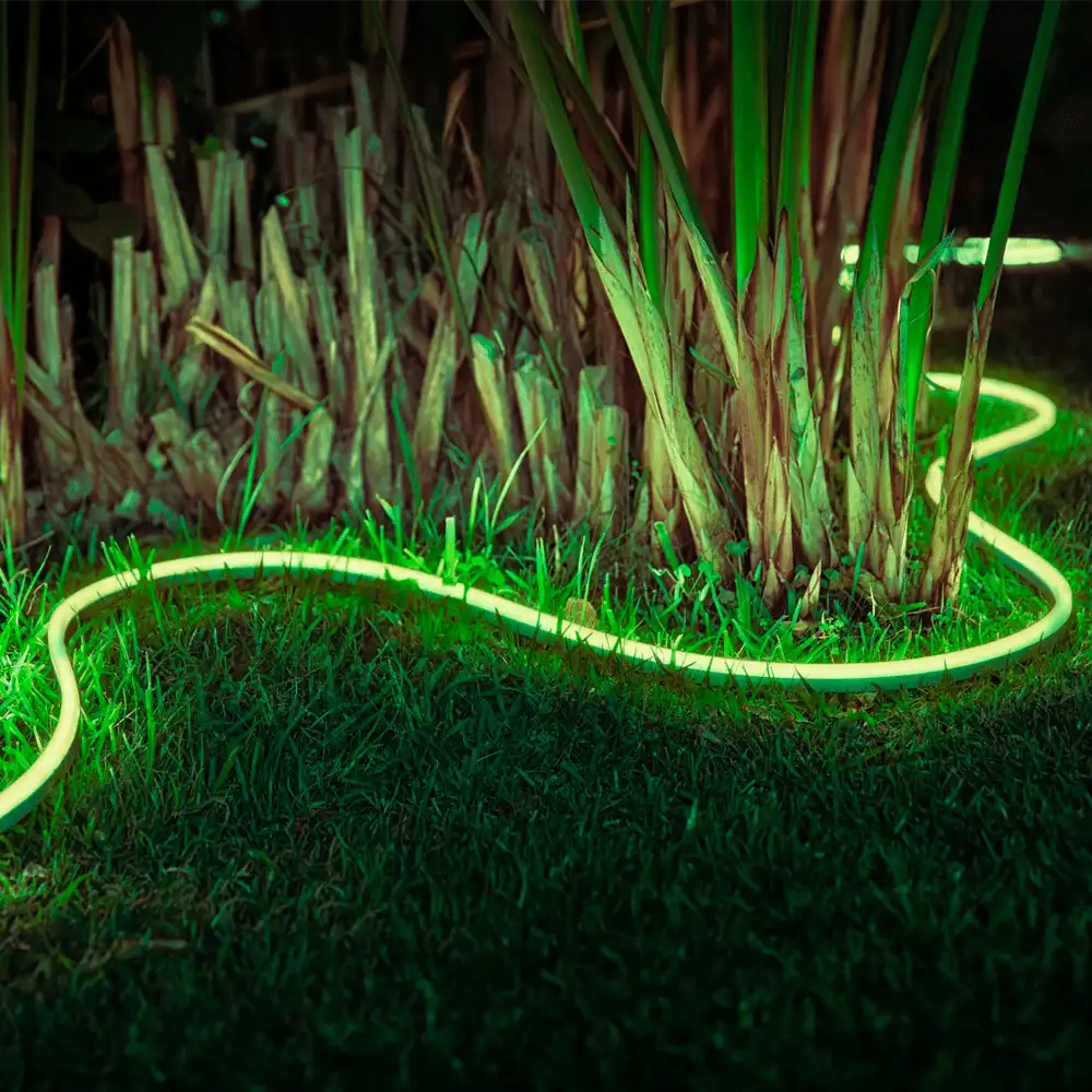Tira LED exterior 2 metros Philips Hue Lightstrip White and Color iluminando jardín en color verde